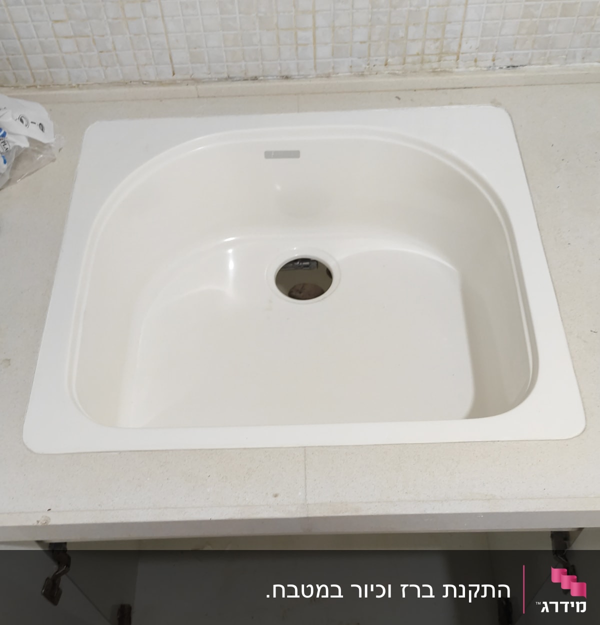 כיור מטבח לבן עם ארון פתוח מתחתיו